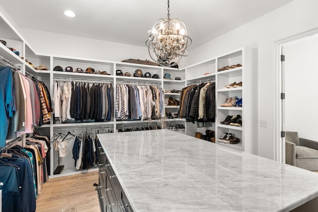 walk in closet featuring a notable chandelier and light wood-type flooring