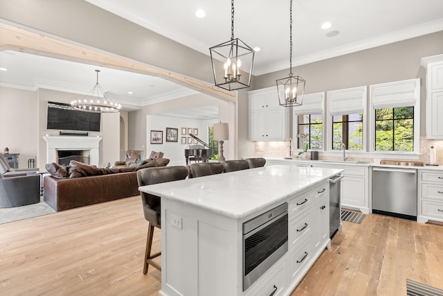 kitchen with appliances with stainless steel finishes, a center island, and white cabinets