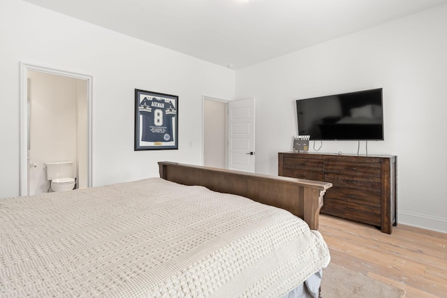 bedroom featuring ensuite bathroom and hardwood / wood-style floors