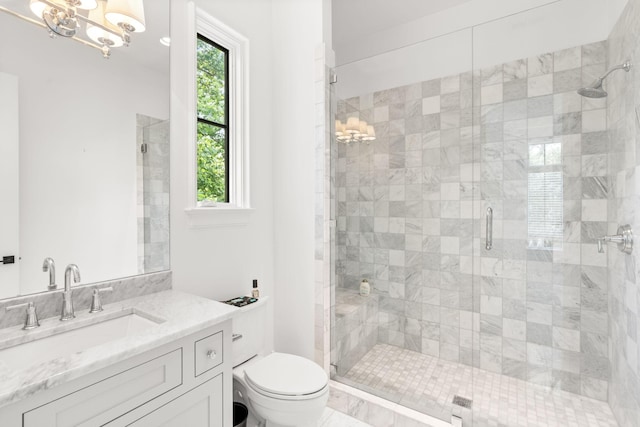 bathroom featuring a chandelier, vanity, toilet, and an enclosed shower