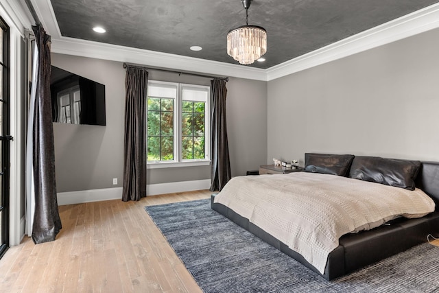 bedroom with ornamental molding, a chandelier, and light hardwood / wood-style floors