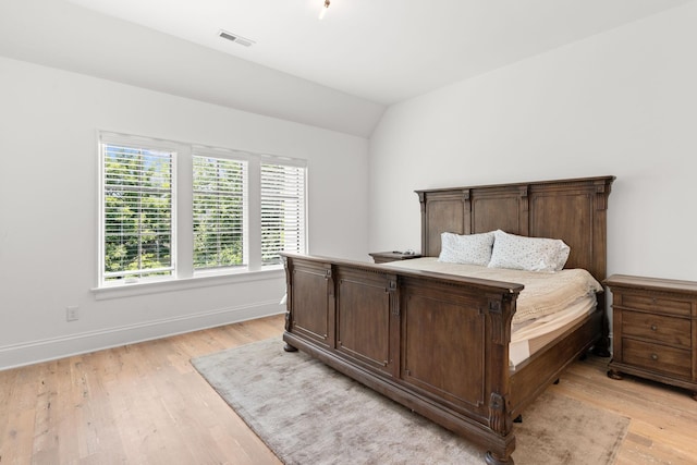 bedroom featuring lofted ceiling and light hardwood / wood-style flooring