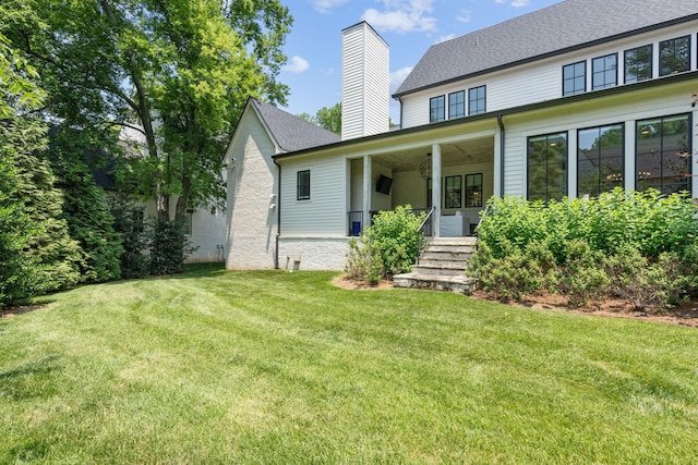 back of house with a lawn and covered porch