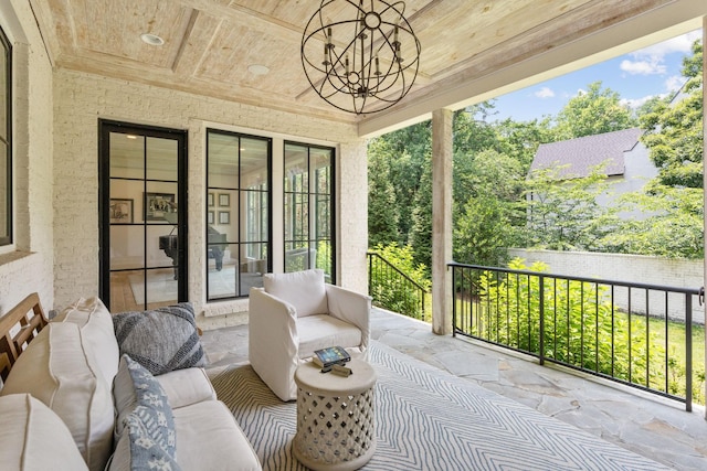 sunroom / solarium featuring a chandelier and wooden ceiling