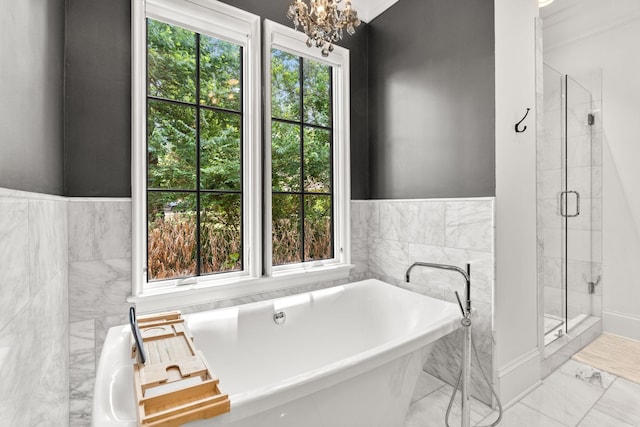 bathroom with independent shower and bath and an inviting chandelier