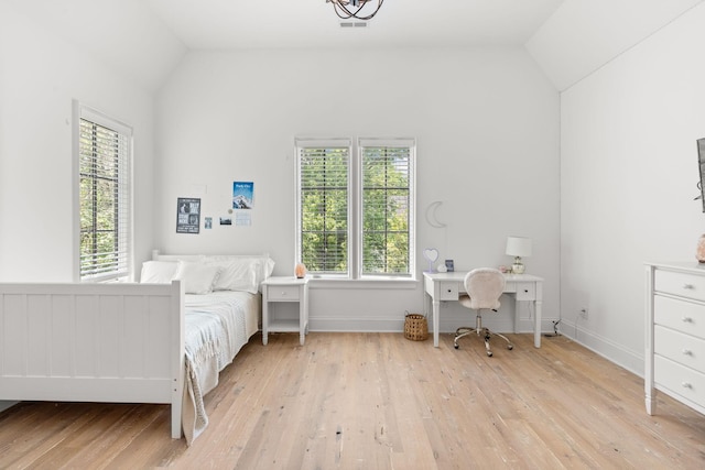 bedroom with vaulted ceiling and light wood-type flooring