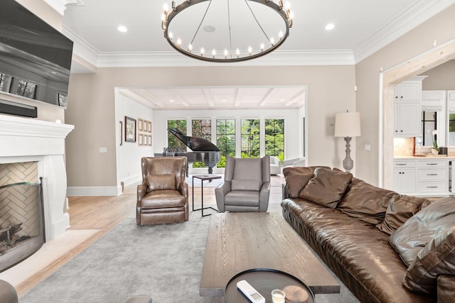 living room with ornamental molding, an inviting chandelier, and light hardwood / wood-style floors