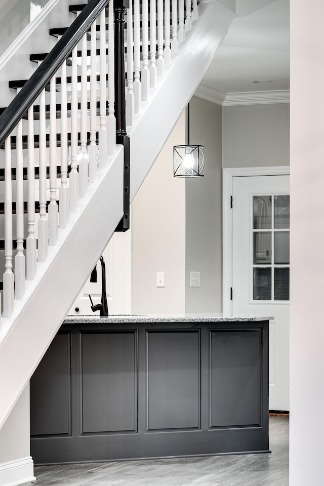 stairs featuring ornamental molding and hardwood / wood-style floors