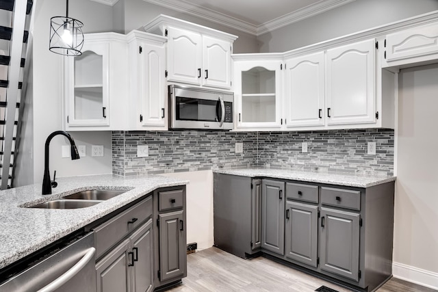 kitchen with sink, gray cabinets, stainless steel appliances, light stone countertops, and white cabinets