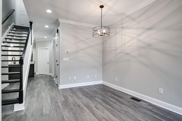 unfurnished dining area featuring a notable chandelier, ornamental molding, and dark hardwood / wood-style floors