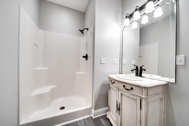 bathroom featuring a shower, hardwood / wood-style floors, and vanity