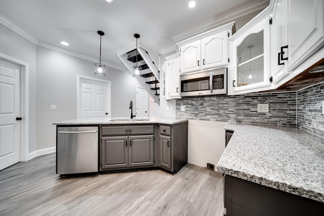 kitchen with sink, white cabinetry, ornamental molding, appliances with stainless steel finishes, and gray cabinets