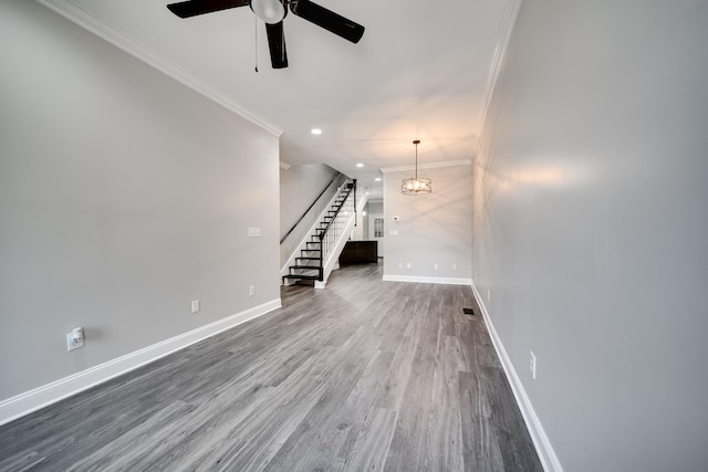 unfurnished living room with hardwood / wood-style flooring, ornamental molding, and ceiling fan