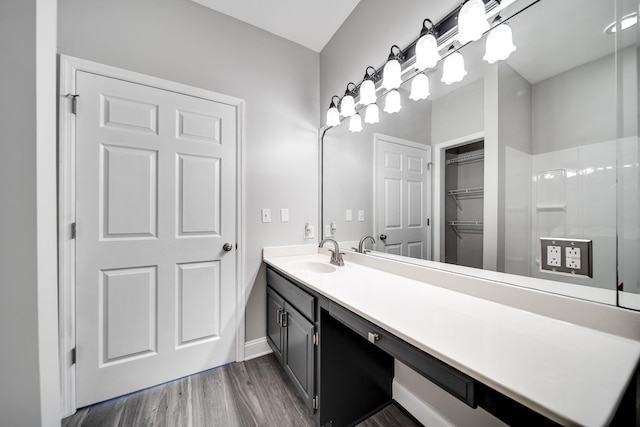 bathroom featuring walk in shower, wood-type flooring, and vanity