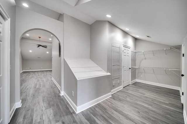 hall with lofted ceiling and hardwood / wood-style floors