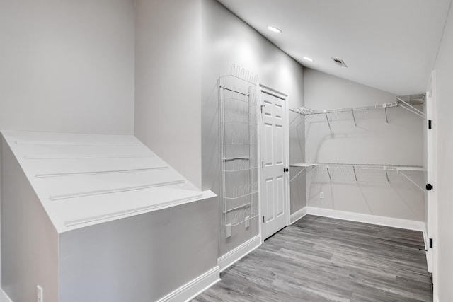 walk in closet featuring vaulted ceiling and hardwood / wood-style floors