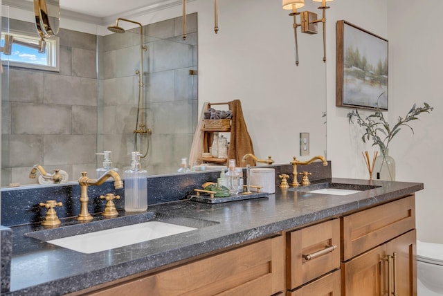 bathroom featuring vanity, tiled shower, and toilet