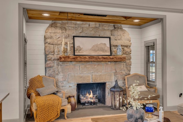 sitting room featuring beamed ceiling and a stone fireplace