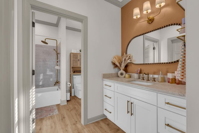 full bathroom featuring vanity, wood-type flooring, toilet, and tiled shower / bath