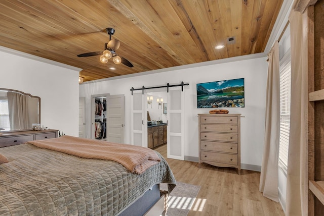 bedroom with multiple windows, a barn door, wood ceiling, and light hardwood / wood-style floors