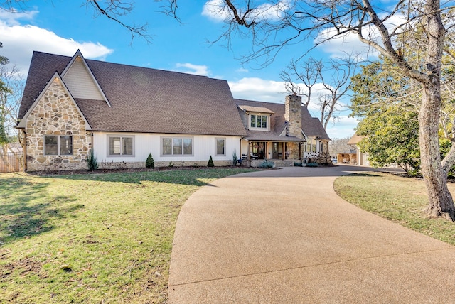 309 Cleveland Ave W, Monterey, TN 38574 - view of front of house featuring a chimney, a front lawn, concrete driveway, a shingled roof, and stone siding