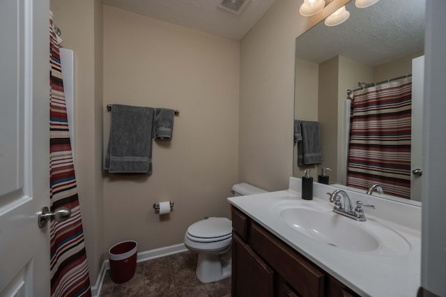 bathroom with vanity, toilet, tile patterned flooring, and a textured ceiling