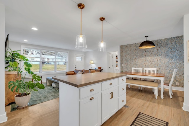 kitchen with pendant lighting, a center island, light hardwood / wood-style flooring, and white cabinets