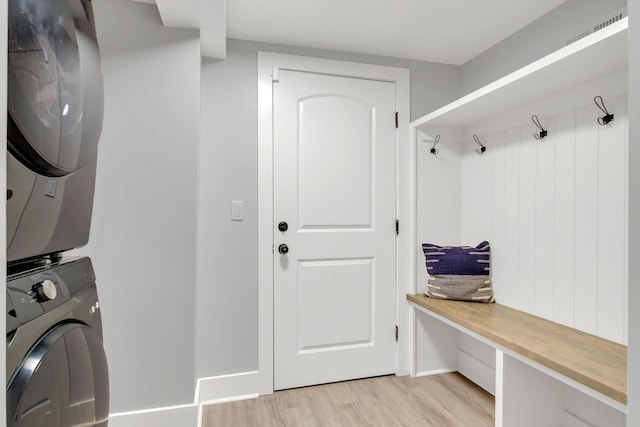 clothes washing area with stacked washer / dryer and light hardwood / wood-style floors