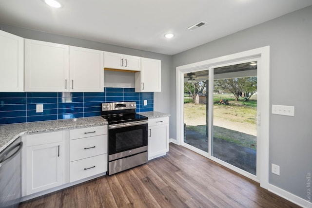 kitchen with light stone countertops, appliances with stainless steel finishes, white cabinets, and decorative backsplash