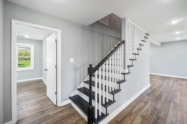 staircase with hardwood / wood-style floors