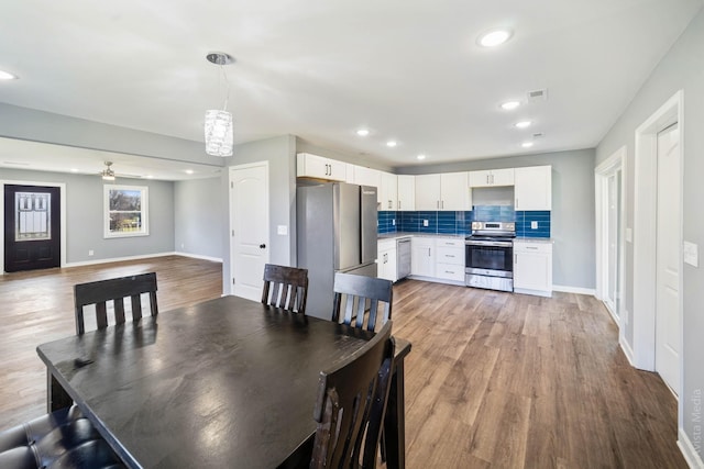 dining space with light hardwood / wood-style floors and ceiling fan