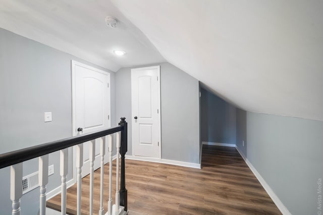 bonus room featuring vaulted ceiling and dark wood-type flooring