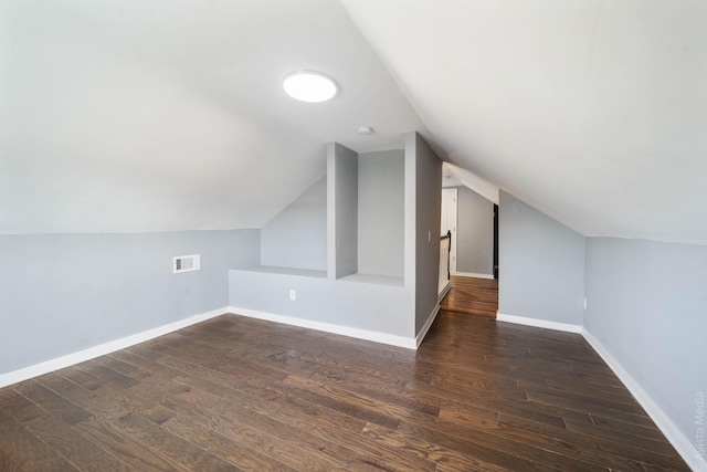 bonus room with lofted ceiling and dark hardwood / wood-style flooring