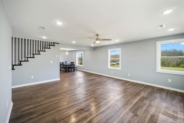 unfurnished living room featuring ceiling fan and dark hardwood / wood-style flooring