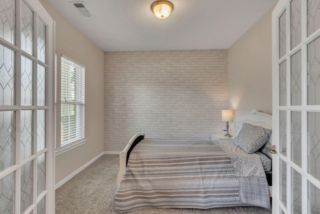 bedroom with brick wall and carpet