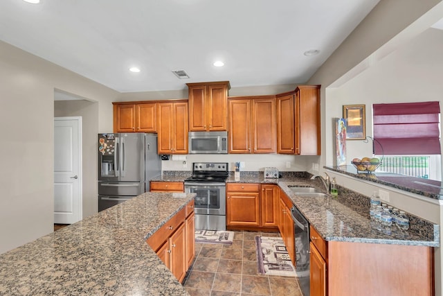 kitchen featuring appliances with stainless steel finishes, sink, and dark stone counters