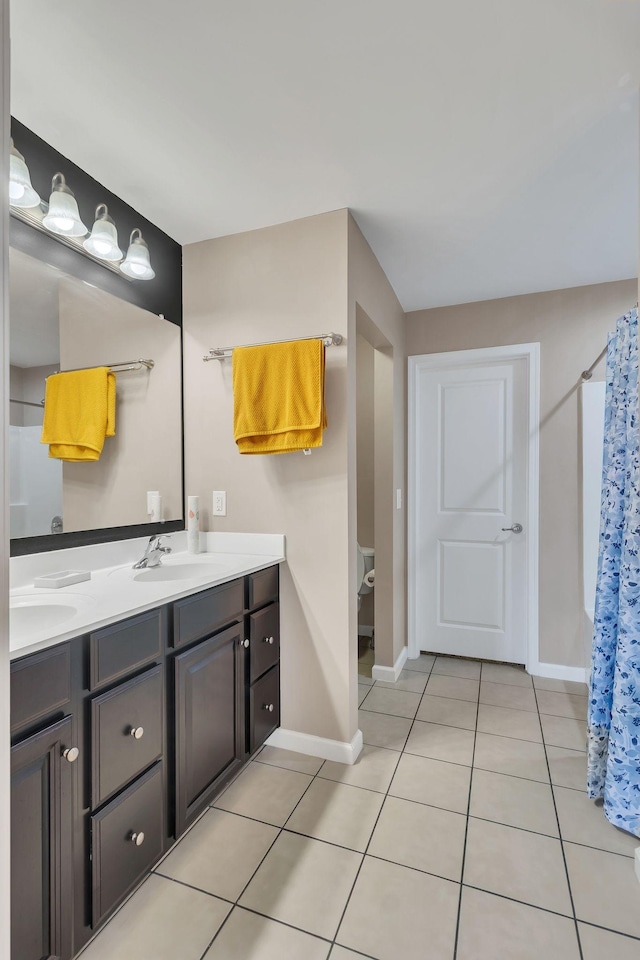 bathroom featuring tile patterned floors, toilet, curtained shower, and vanity