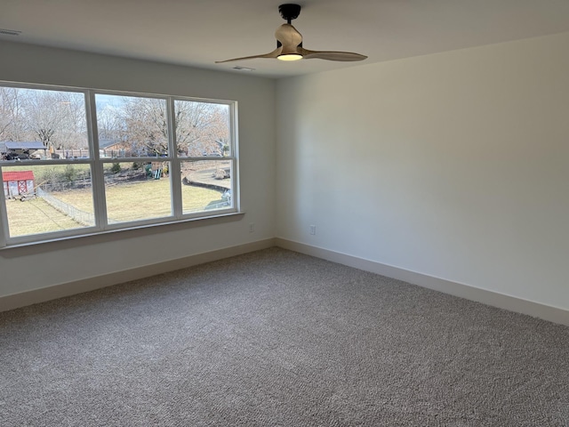 carpeted spare room featuring ceiling fan