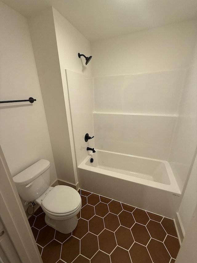 bathroom with tile patterned flooring, tub / shower combination, and toilet