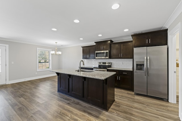 kitchen with sink, crown molding, a center island with sink, pendant lighting, and stainless steel appliances