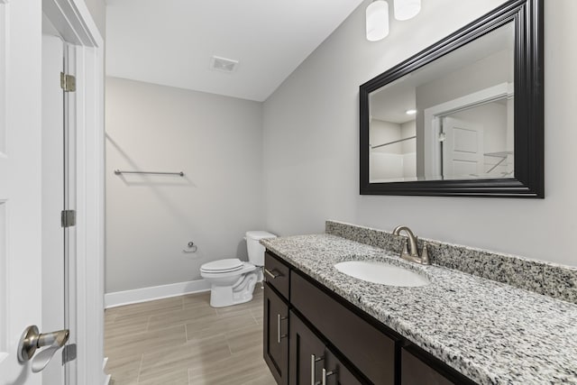 bathroom featuring vanity, a shower, and toilet