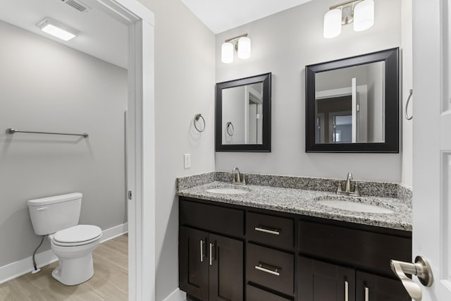 bathroom with vanity, wood-type flooring, and toilet