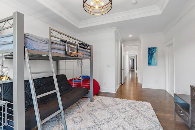 bedroom featuring crown molding, a tray ceiling, and dark hardwood / wood-style floors