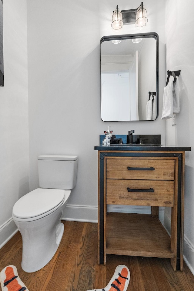 bathroom with vanity, toilet, and hardwood / wood-style floors