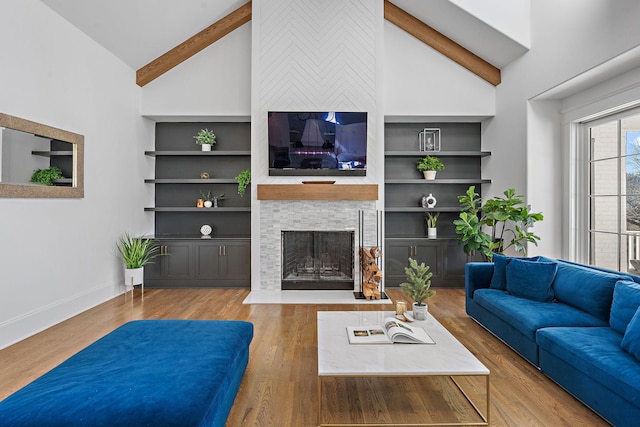 living room with built in shelves, high vaulted ceiling, beamed ceiling, and hardwood / wood-style flooring