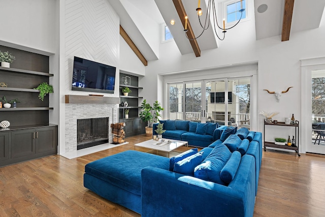 living room with beamed ceiling, hardwood / wood-style floors, and a wealth of natural light