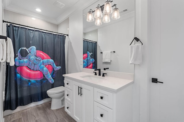 bathroom featuring crown molding, hardwood / wood-style flooring, vanity, toilet, and walk in shower