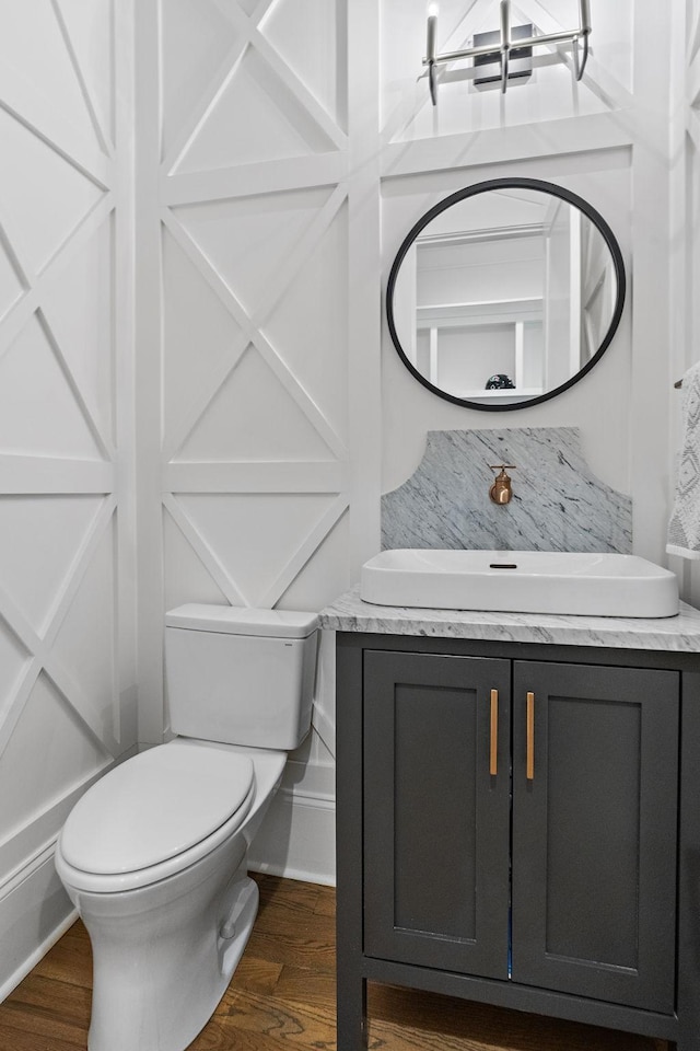 bathroom with hardwood / wood-style flooring, vanity, and toilet