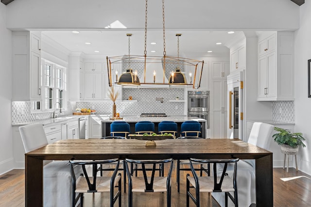 kitchen featuring white cabinetry, a breakfast bar, a center island, and hanging light fixtures