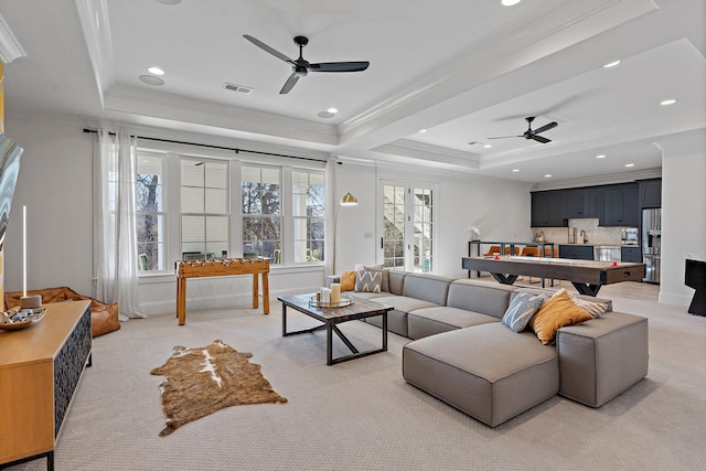 carpeted living room with a raised ceiling, crown molding, ceiling fan, and billiards